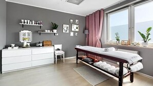 A modern bedroom with a bed, bedside table, dresser, and a window with curtains. - Land-gut-hotel Olympic (Wronki)