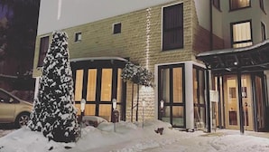 A modern building with a flat roof, multiple windows, and a snow-covered entrance. - Stadt-gut-hotel Astra (Ulm)