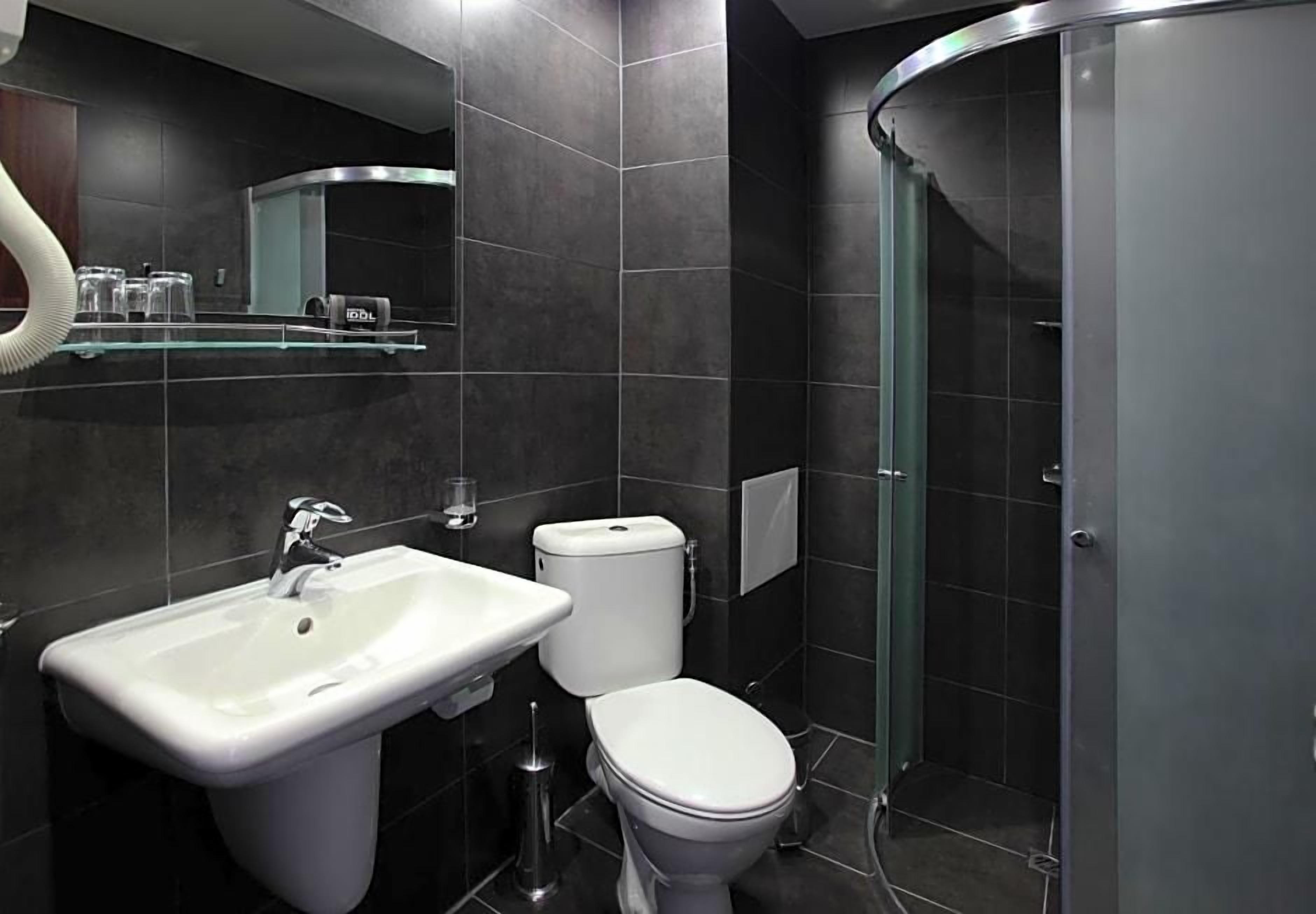 Un baño moderno con lavamanos, inodoro y cabina de ducha de vidrio.