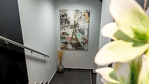 A staircase with a wall-mounted poster featuring the Eiffel Tower and various words. - Hotel Idol (Targovishte)