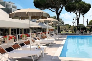 A poolside area with sun loungers, umbrellas, and a pool. - Villagio La Darsena (Scarlino)