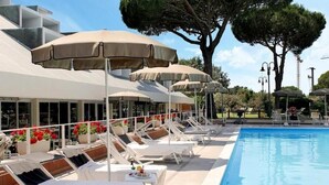 A poolside area with sun loungers, umbrellas, and a pool. - Villagio La Darsena (Scarlino)