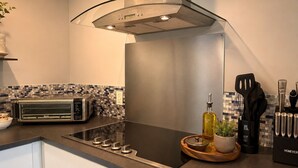 A modern kitchen with a built-in oven, a toaster, and a range hood.
