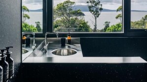 A kitchen with a large window overlooking a scenic view of mountains and trees.