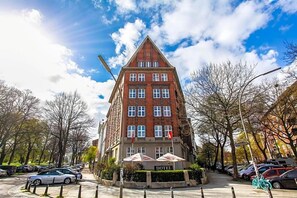 Un hotel con una fachada de ladrillo rojo destacada, múltiples ventanas y un letrero que indica que es un hotel.