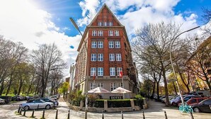 A hotel with a prominent red brick facade, multiple windows, and a sign indicating it is a hotel. - Fresena (Hamburg)