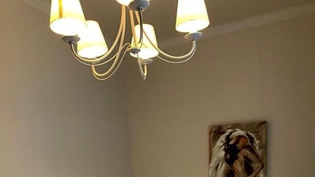 A hotel room with two beds, a chandelier, and a painting on the wall. - Fresena (Hamburg)