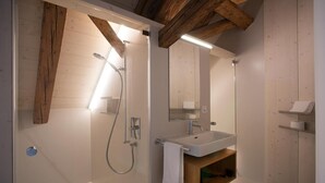 A modern bathroom with a shower, sink, and wooden beams. - Gasthaus Zum Trauben (Weinfelden)