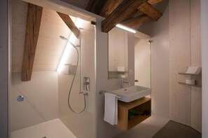 A modern bathroom with a shower, sink, and wooden beams. - Gasthaus Zum Trauben (Weinfelden)