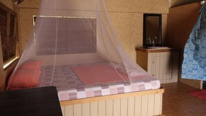 A room with a bed, a small sink, and a mirror. - Tetamanu Village (Fakarava)