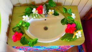 A bathroom sink with a white basin, a faucet, and decorative flowers and leaves.