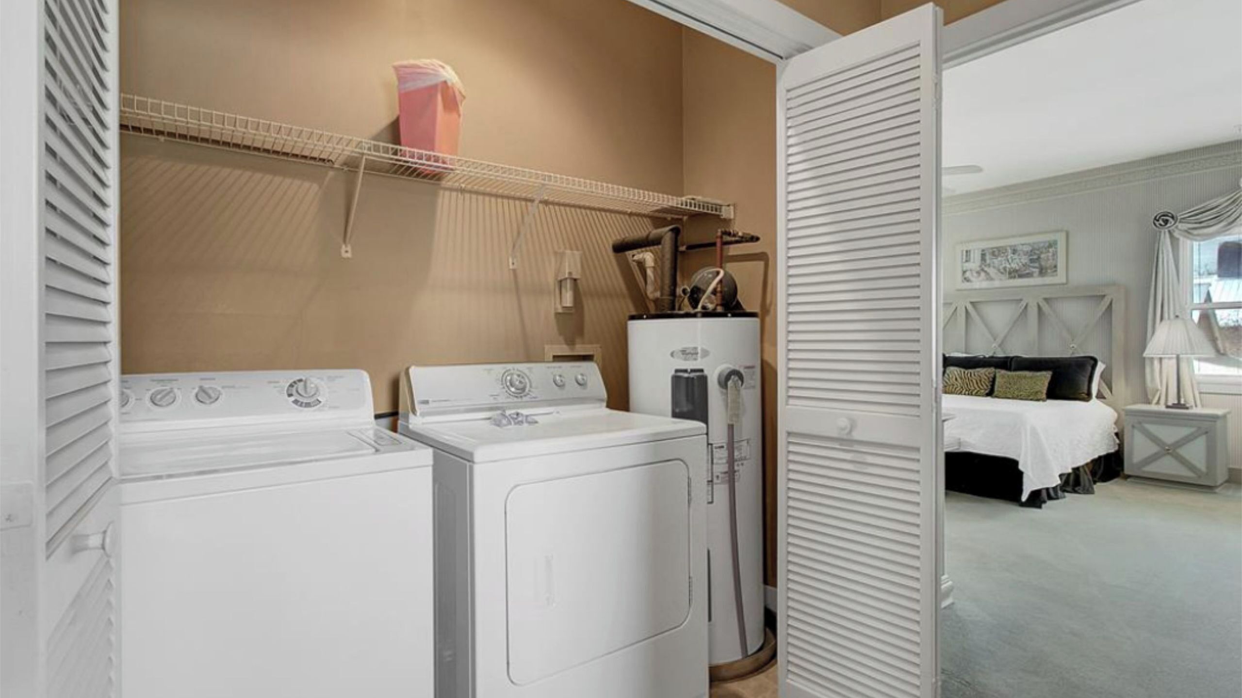 A laundry area with a dryer, washing machine, and a water heater.