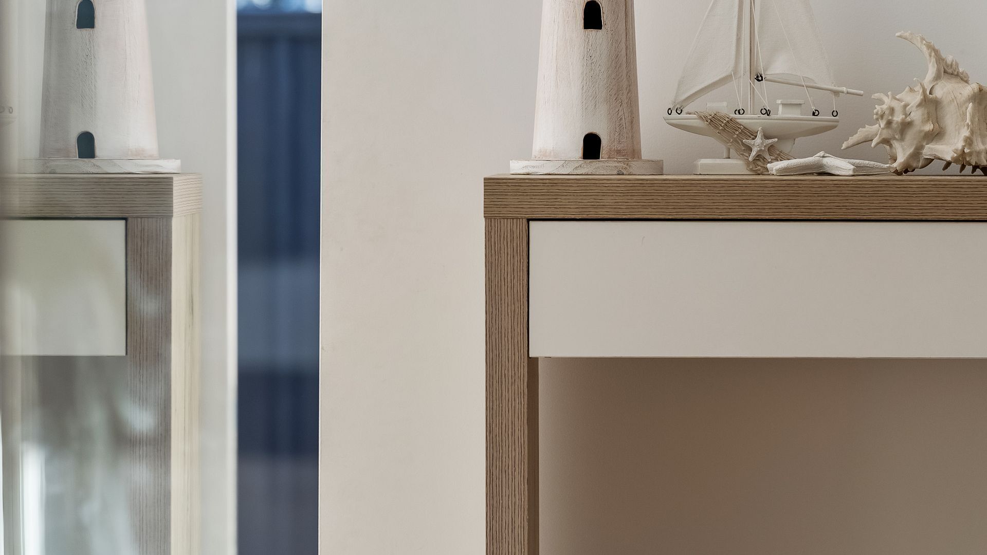 A wooden table with a sailboat model and a starfish decoration.