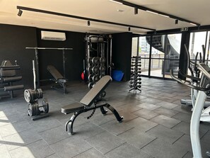 Ein Fitnessstudio mit Gewichten, einer Bank und einem Laufband.