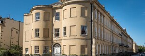 A historic building with a curved facade, a prominent entrance with a sign reading 'Dukes Hotel,' and a series of windows along the upper level. - Dukes Hotel (Bath)