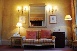 A room with a sofa, a table with a lamp, a mirror, and wall-mounted sconces. - Dukes Hotel (Bath)