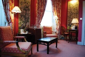 A room with floral wallpaper, a sofa, two chairs, a table, and lamps. - Dukes Hotel (Bath)