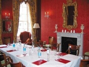 A dining room with a table set for four, a fireplace, and a mirror on the wall. - Dukes Hotel (Bath)