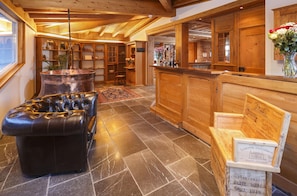 A wooden interior with a leather sofa, a bar area, and a display of wine boxes. - Griesalp Hotelzentrum (Reichenbach im Kandertal)