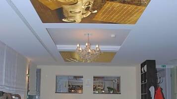 A restaurant with multiple tables, chairs, and a chandelier.
