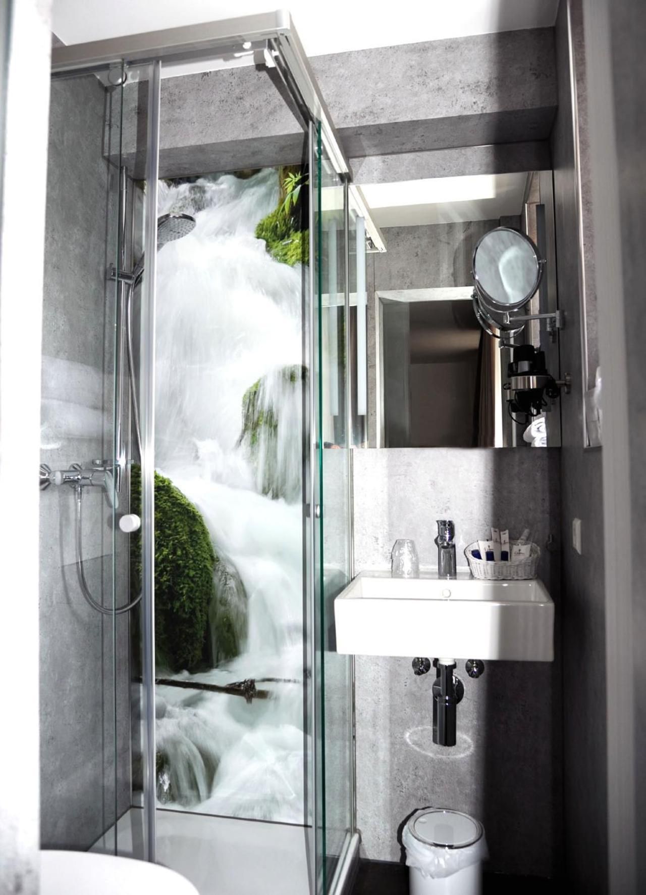 A modern bathroom with a glass-enclosed shower, a sink, and a mirror.