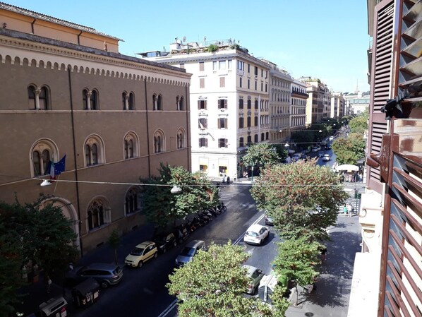 A street view with buildings, parked cars, and trees. - Terrazza Cola Di Rienzo - Two Bedroom (Rome)