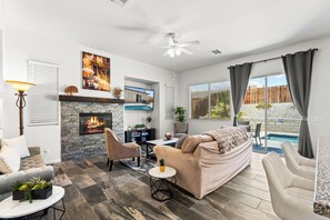 A living room with a fireplace, a pool, and a ceiling fan. - Desert Fun Retreat with Mini Golf Pool & Hot Tub
New Listing Enjoy special price (Desert Hot Springs)