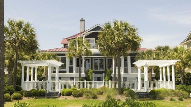 A large house with a covered porch, palm trees, and a well-maintained lawn. - 3902 Palm Blvd by Avantstay Beach Access! Oceanfront Views w/ Pool (Isle of Palms)