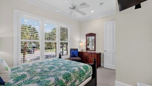 A bedroom with a bed, a dresser, a mirror, and a ceiling fan. - 3902 Palm Blvd by Avantstay Beach Access! Oceanfront Views w/ Pool (Isle of Palms)