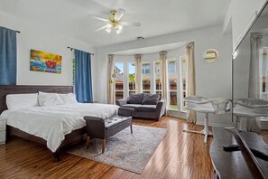 Ein Schlafzimmer mit Bett, Sofa, Schreibtisch und Stuhl.