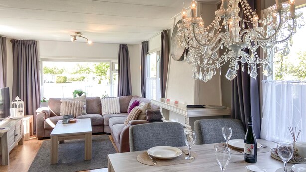 En matplats med ett bord dukat för två personer, en kristallkrona och en soffa i bakgrunden.