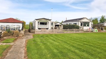 A residential property with a large lawn, a covered porch, and a detached garage.