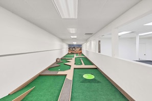 A corridor with green artificial turf, a mural on the far wall, and a door at the end. - Resort 2BR · Pool · Pickleball · 1 Hr to Zion (St. George)