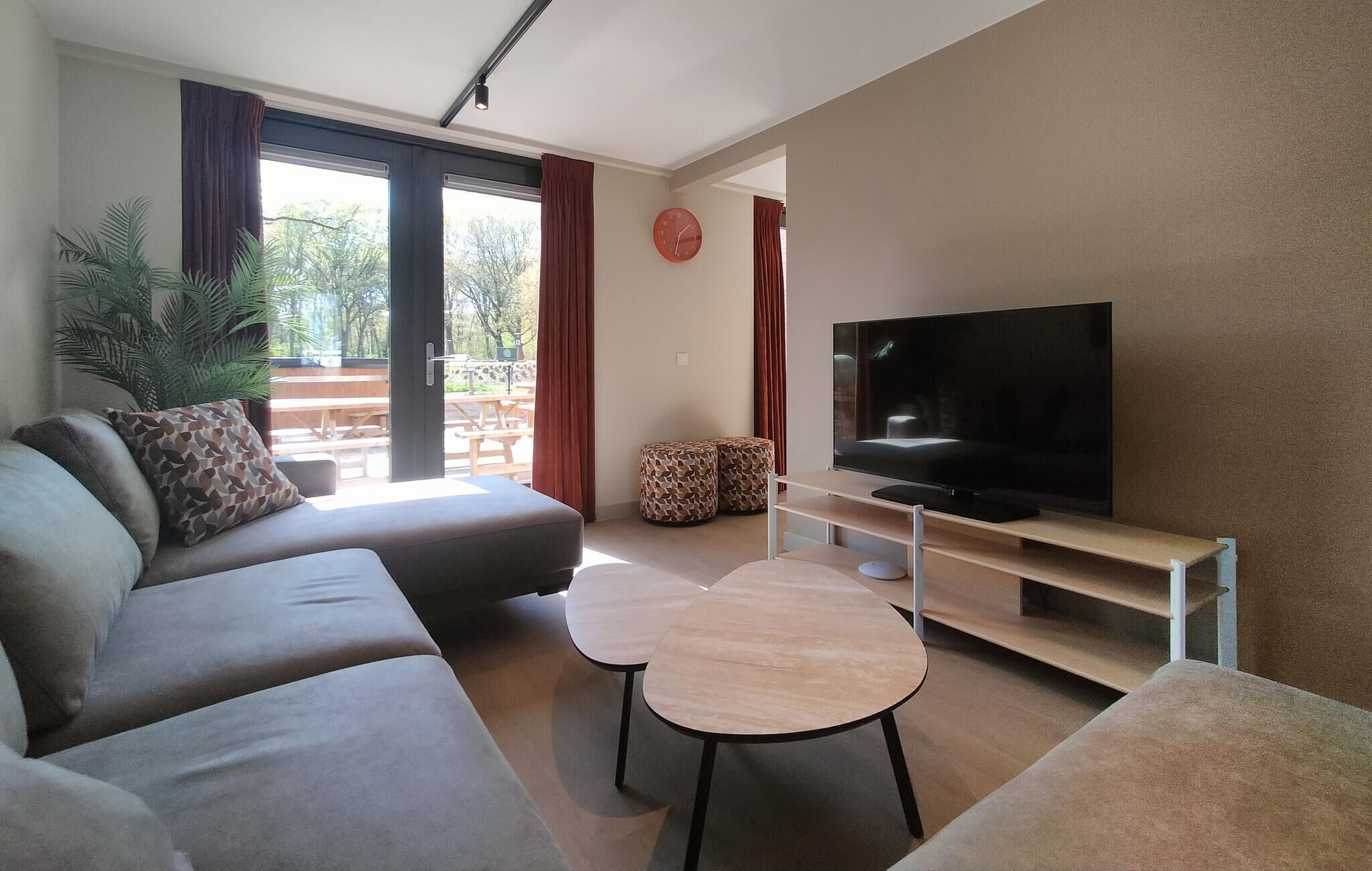 Un salon moderne avec un canapé, un téléviseur et une petite table.