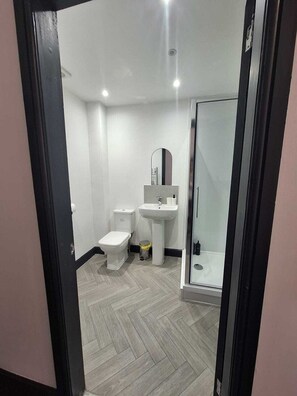 A modern bathroom with a toilet, sink, and shower area.