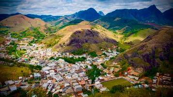Uma cidade aninhada em um vale, com edifícios residenciais e comerciais, cercada por colinas e montanhas.