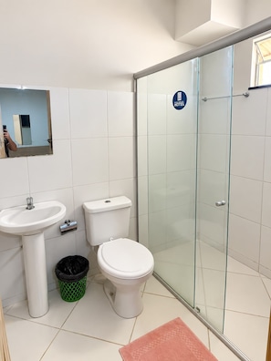 Une salle de bain moderne avec une douche à parois de verre, un lavabo et des toilettes.