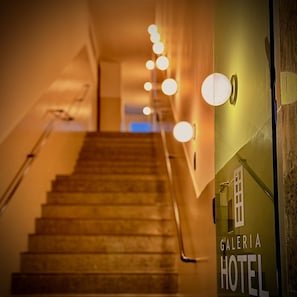 A staircase leading to a hotel entrance with a sign reading 'Galeria Hotel'.