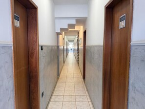 A hotel hallway with doors numbered 01 and 02, leading to rooms. - Galeria Hotel (Lajinha)