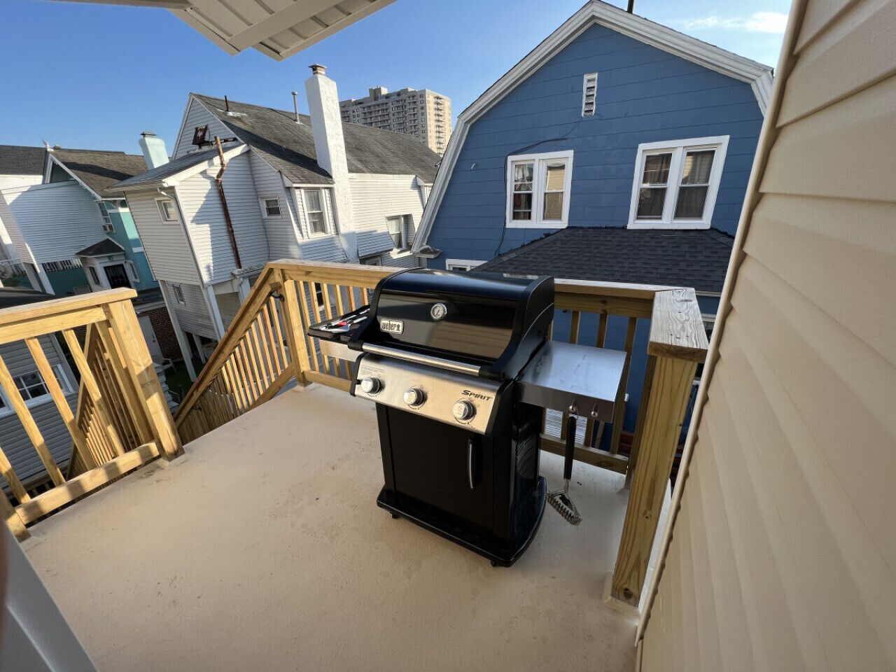 En grill på en balkong med utsikt över de omkringliggande husen.