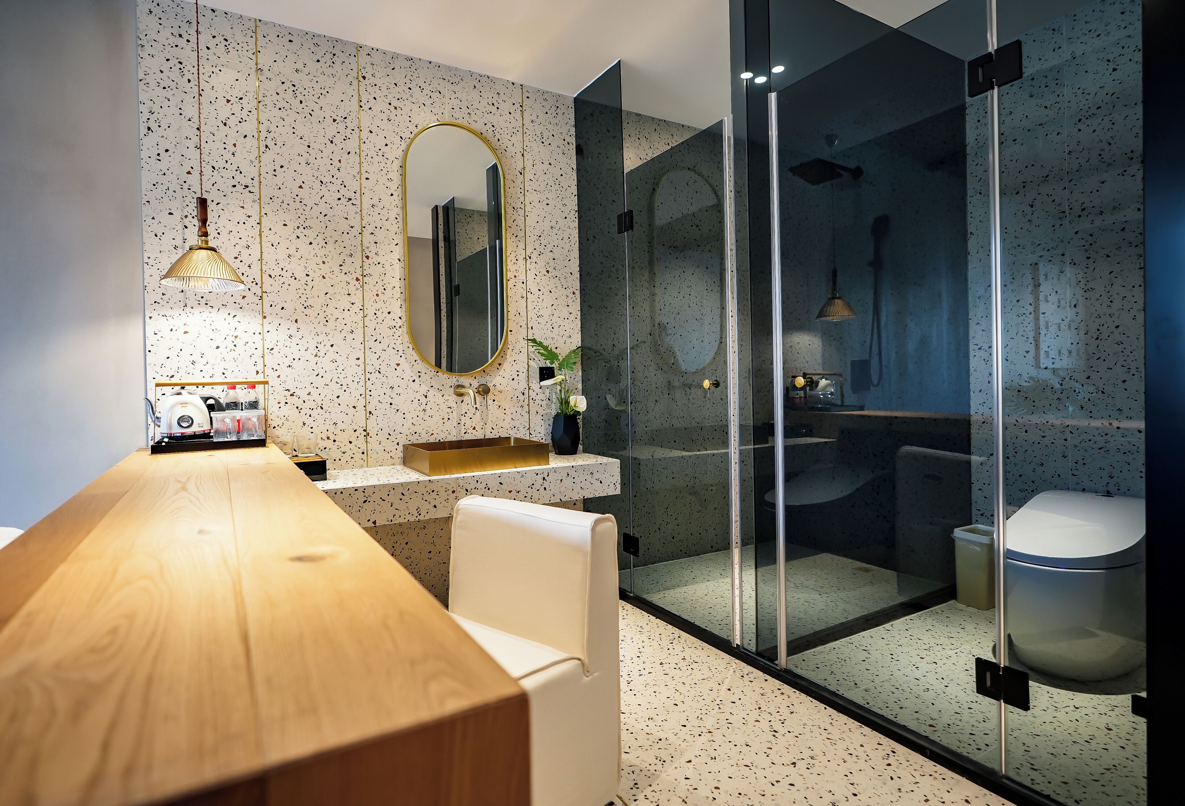 A modern bathroom with a wooden vanity, a large mirror, and a glass-enclosed shower area.
