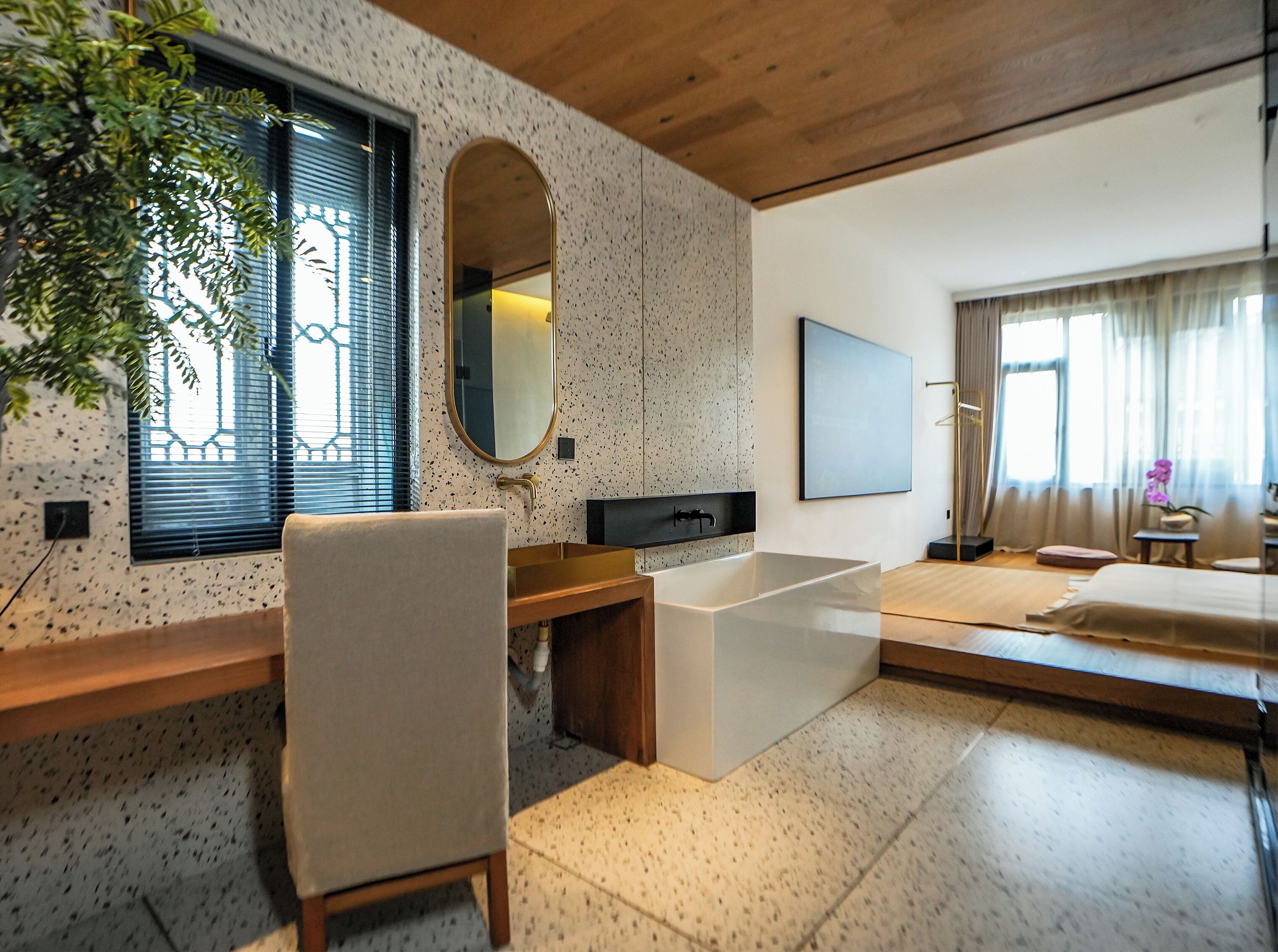 Une salle de bain moderne avec une baignoire sur pieds, un grand miroir et un meuble-lavabo en bois.