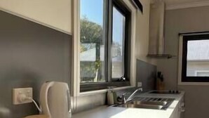 A modern kitchen with a large window, a built-in oven, and a sink. - Collopy Escape Mansfield (Mansfield)