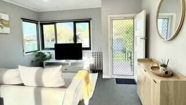 A modern living room with a sofa, a TV, and a wooden cabinet. - Collopy Escape Mansfield (Mansfield)