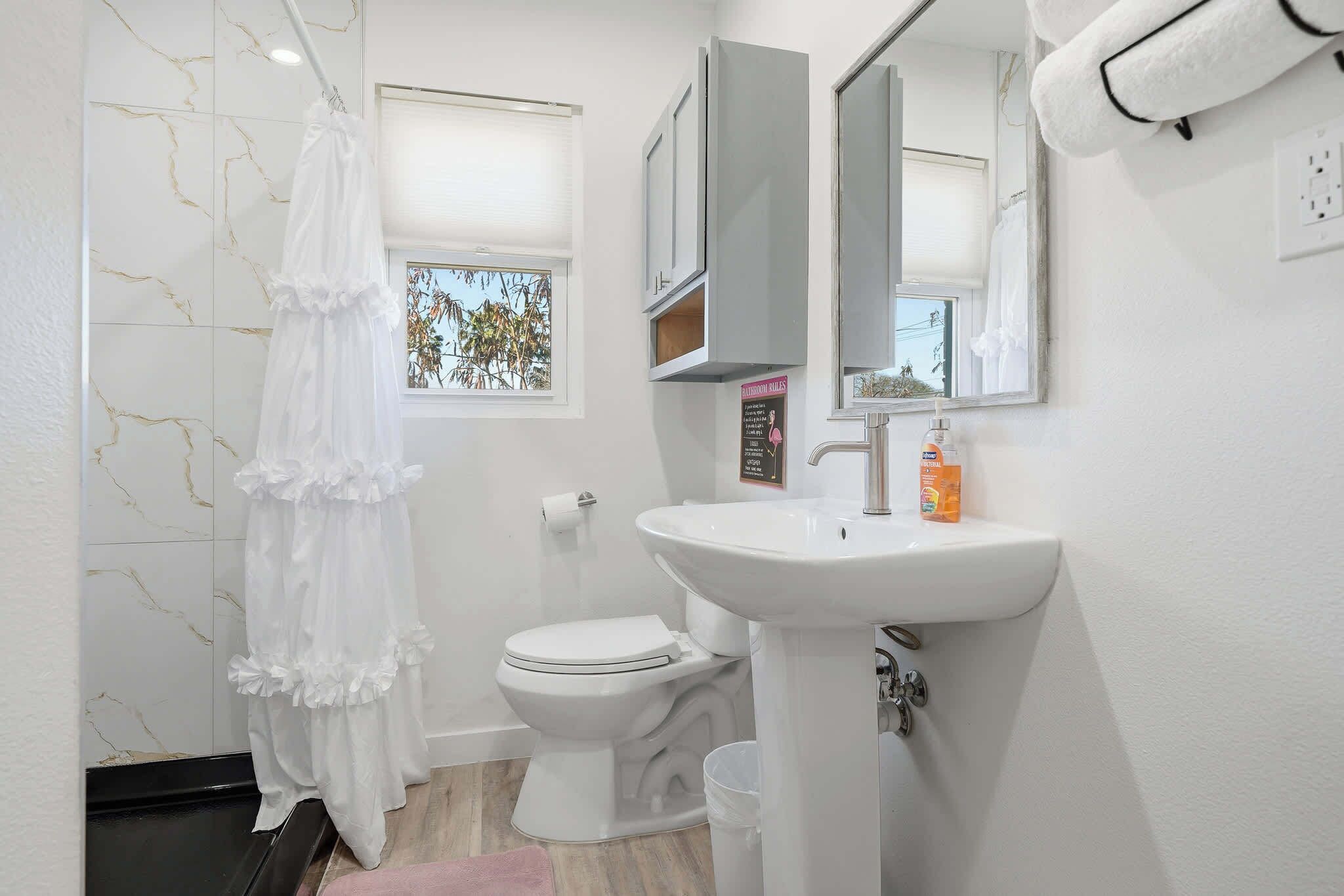 A bathroom with a toilet, sink, and a shower curtain.