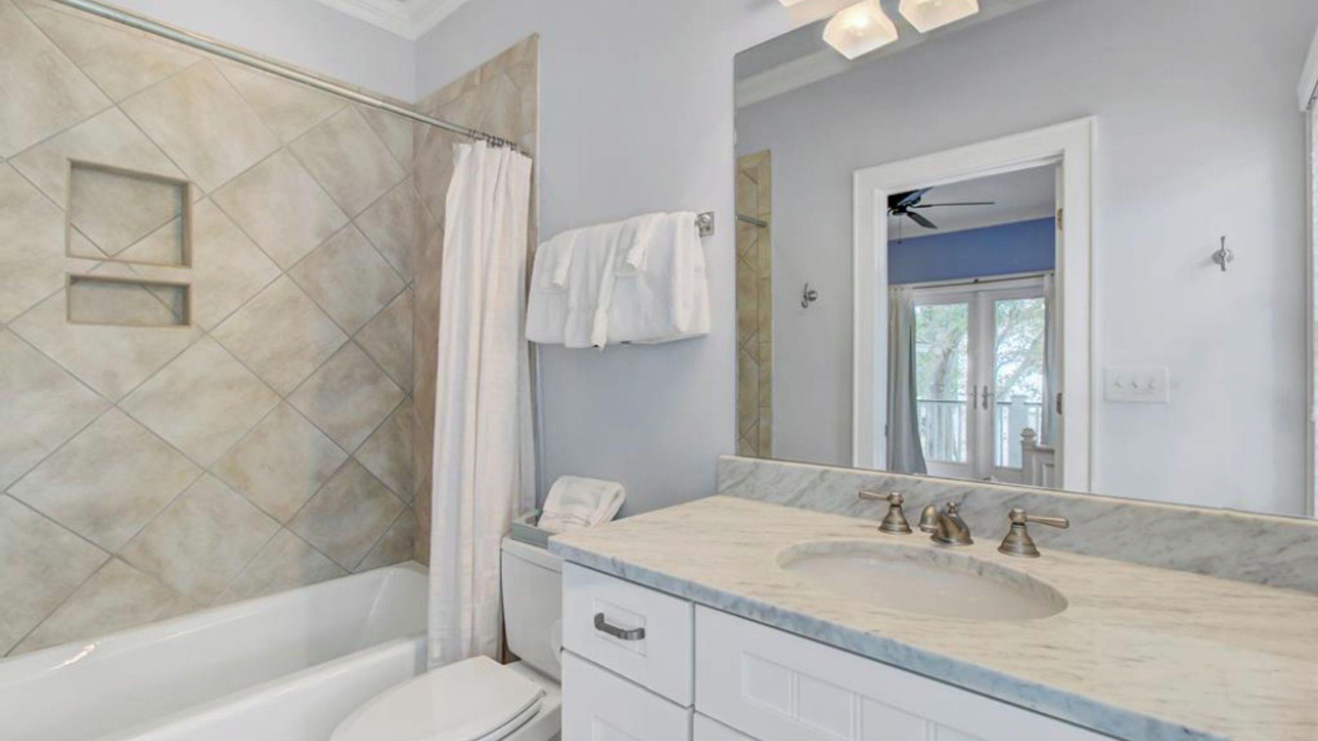 Une salle de bain équipée d’une baignoire, d’une douche, d’un lavabo avec un miroir et de toilettes.