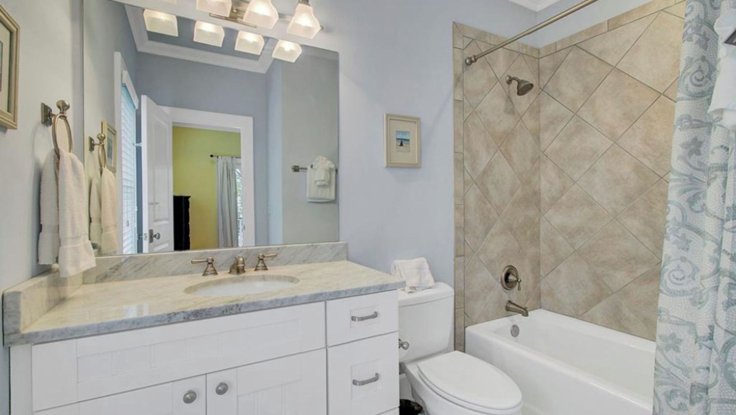 A bathroom with a marble sink, a toilet, a bathtub, and a shower area.