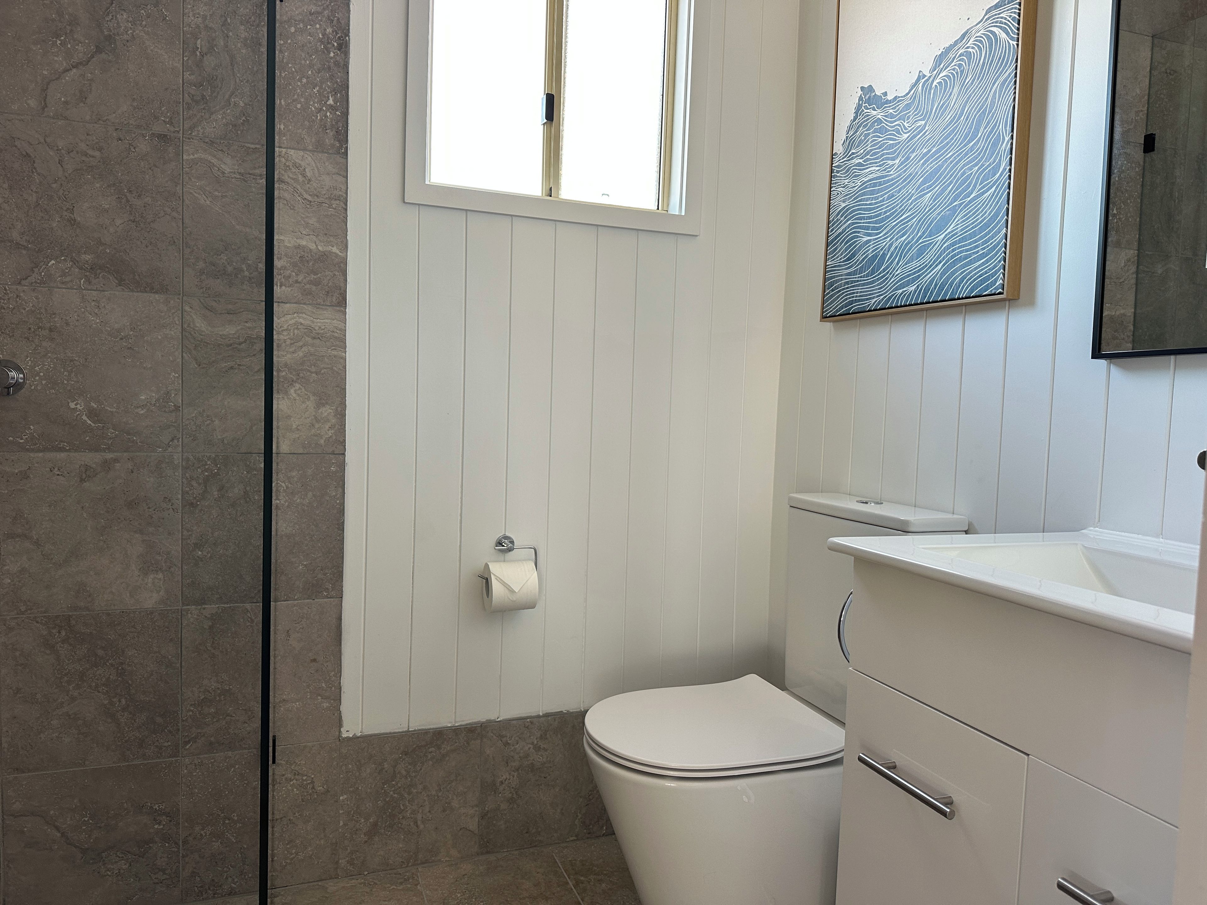 Un bagno con il water, un lavandino e una zona doccia.