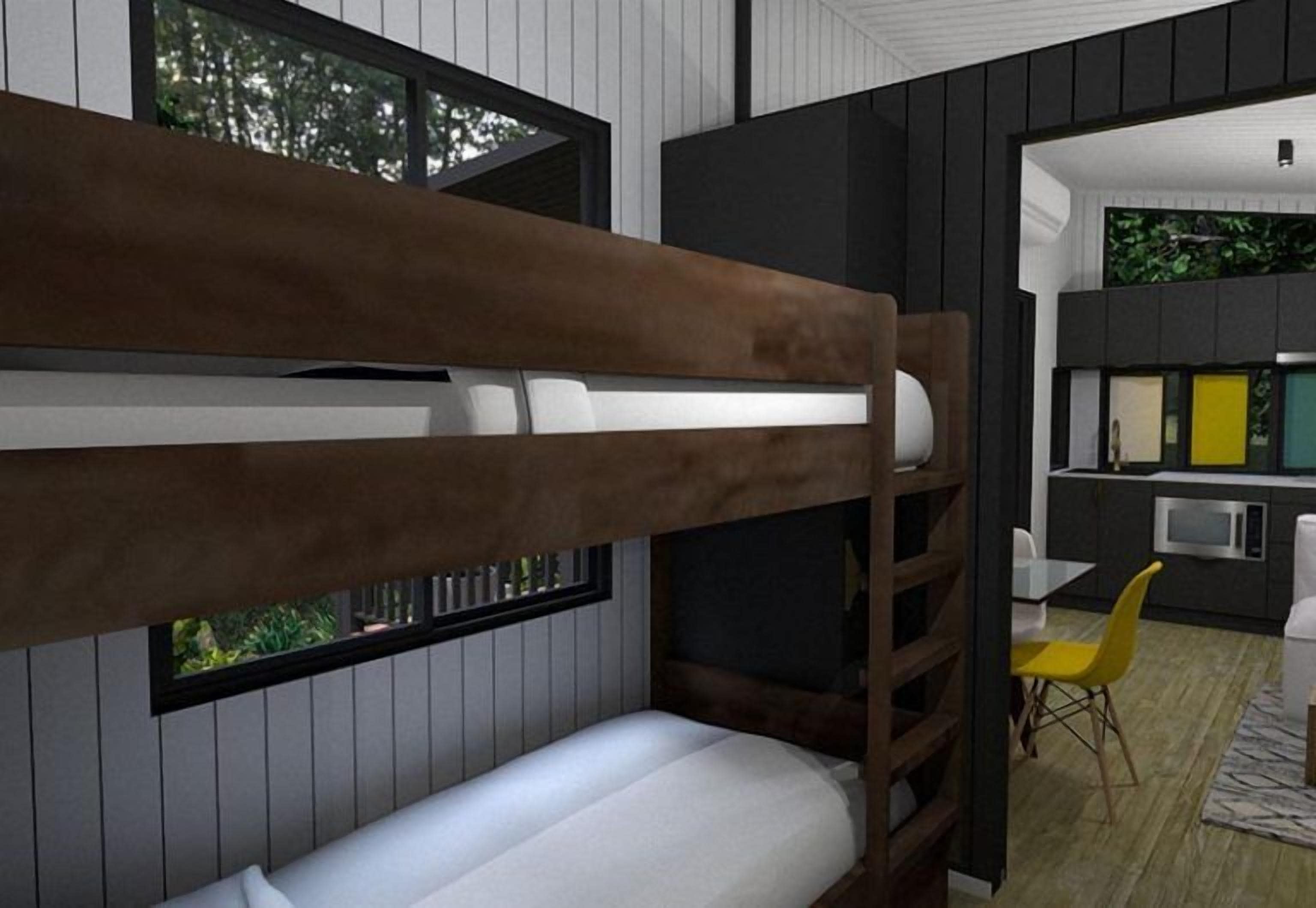 A bunk bed with a window, a kitchen area with a microwave, and a dining table with chairs.