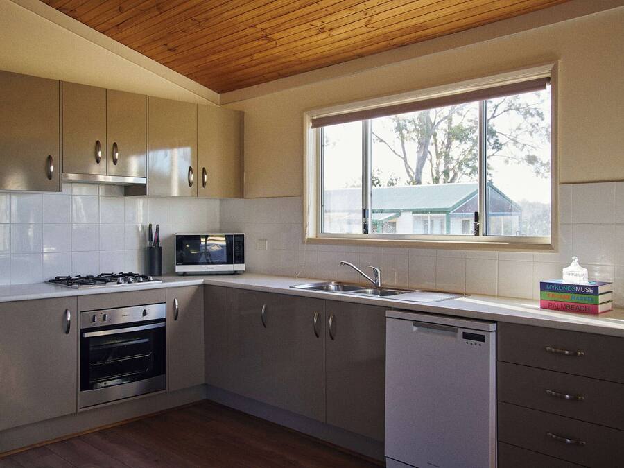 A modern kitchen with stainless steel appliances, a built-in microwave, and a window providing natural light.
